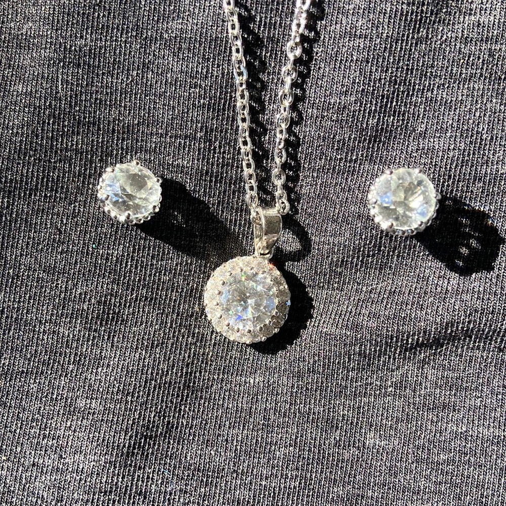 Silver colored chain with crystal pendant necklace and earrings.